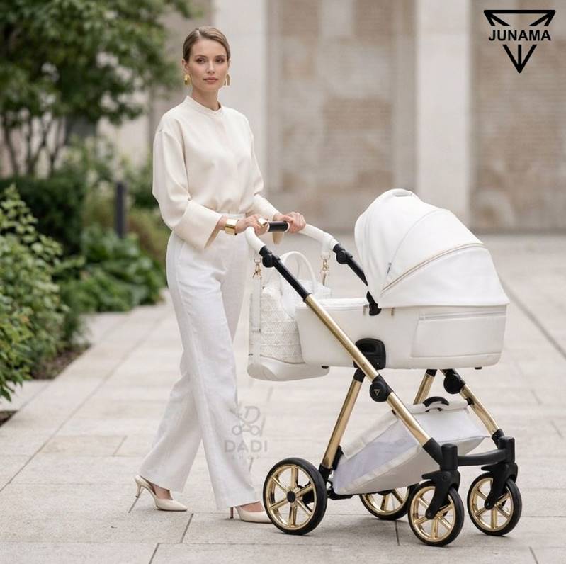 Wózek Junama Art Deco 3w1 w białym kolorze ze złotymi akcentami podczas eleganckiego spaceru